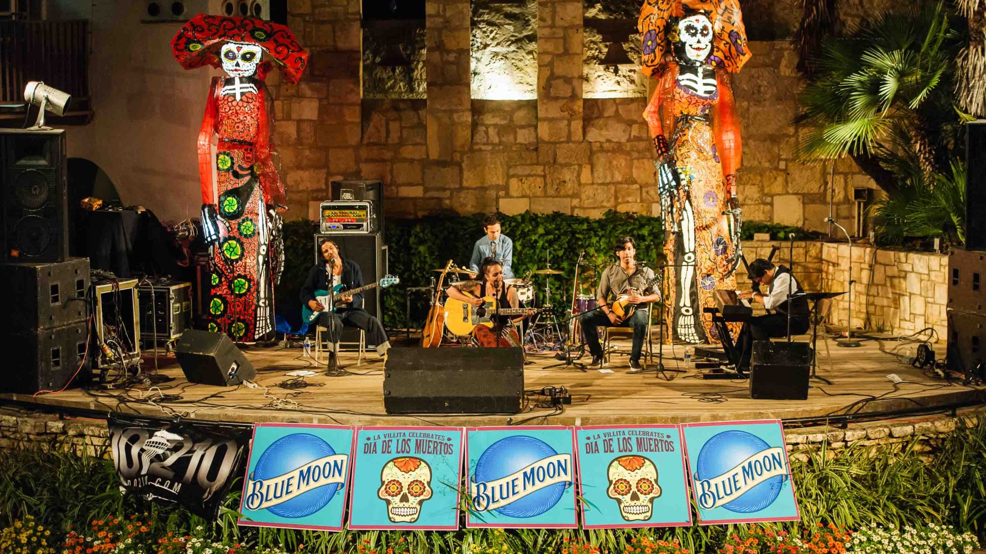 A band plays on a stage at Dia de los muertos celebrations.
