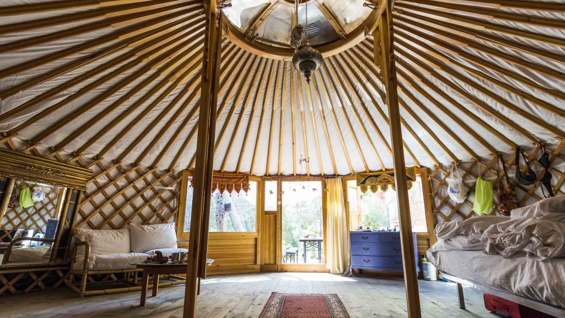 The interior of a yurt with tall beamed ceiling.