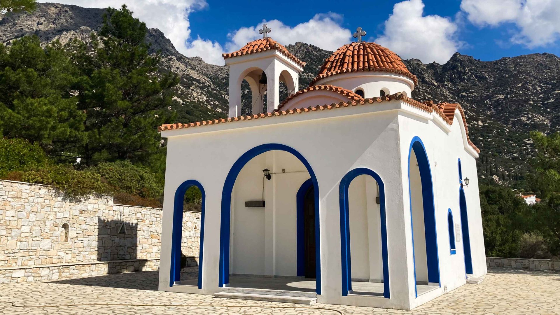 A blue and white church with a terracotta roof.