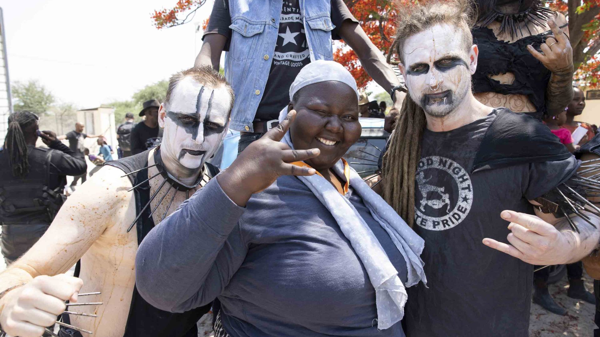 A woman poses with members of a metal band.