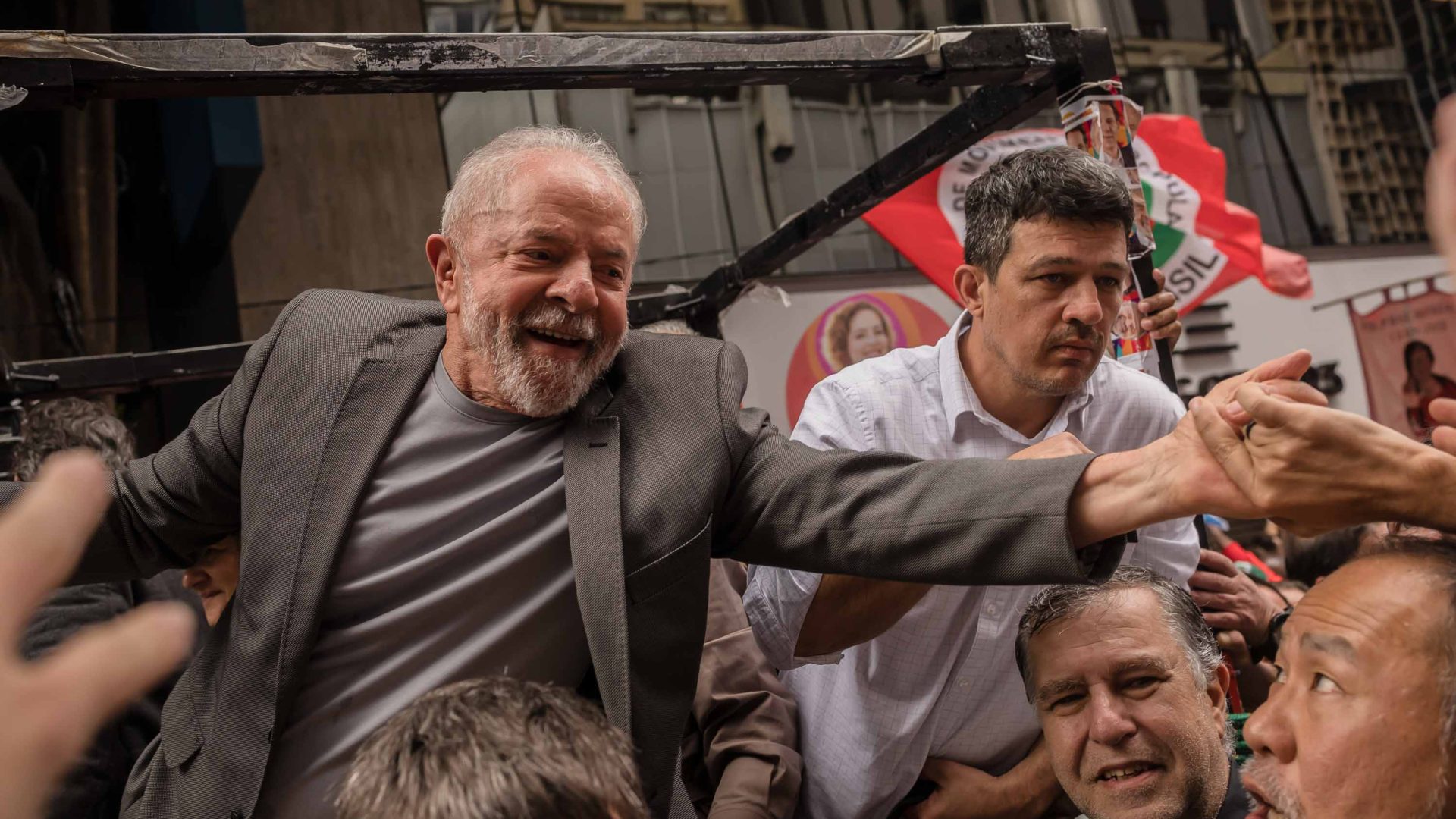 Lula reaches out to supporters in the street.