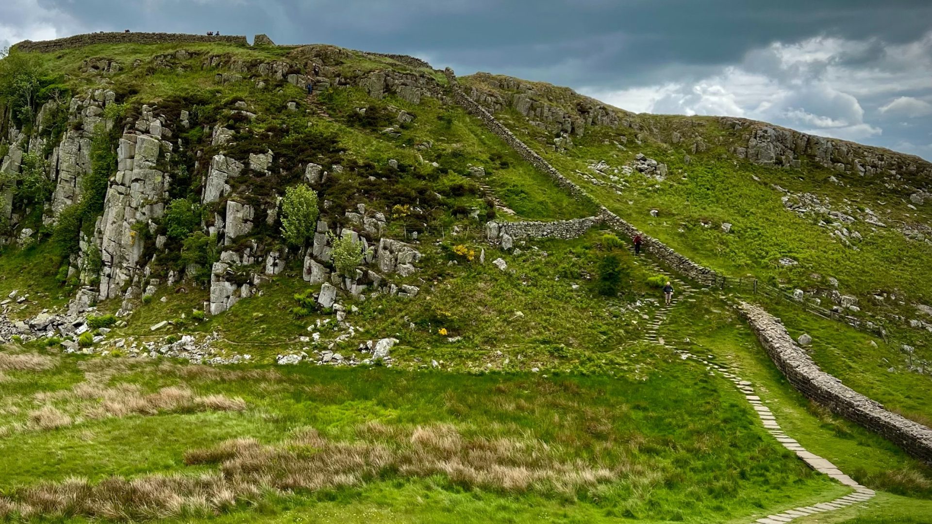 A view of Hadrian’s wall in Northumberland as it runs up a craggy hillside of a Roman fortification
