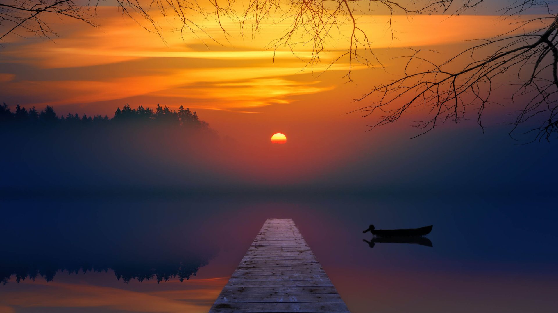 A sun sets over a lake. A jetty leads to the water.
