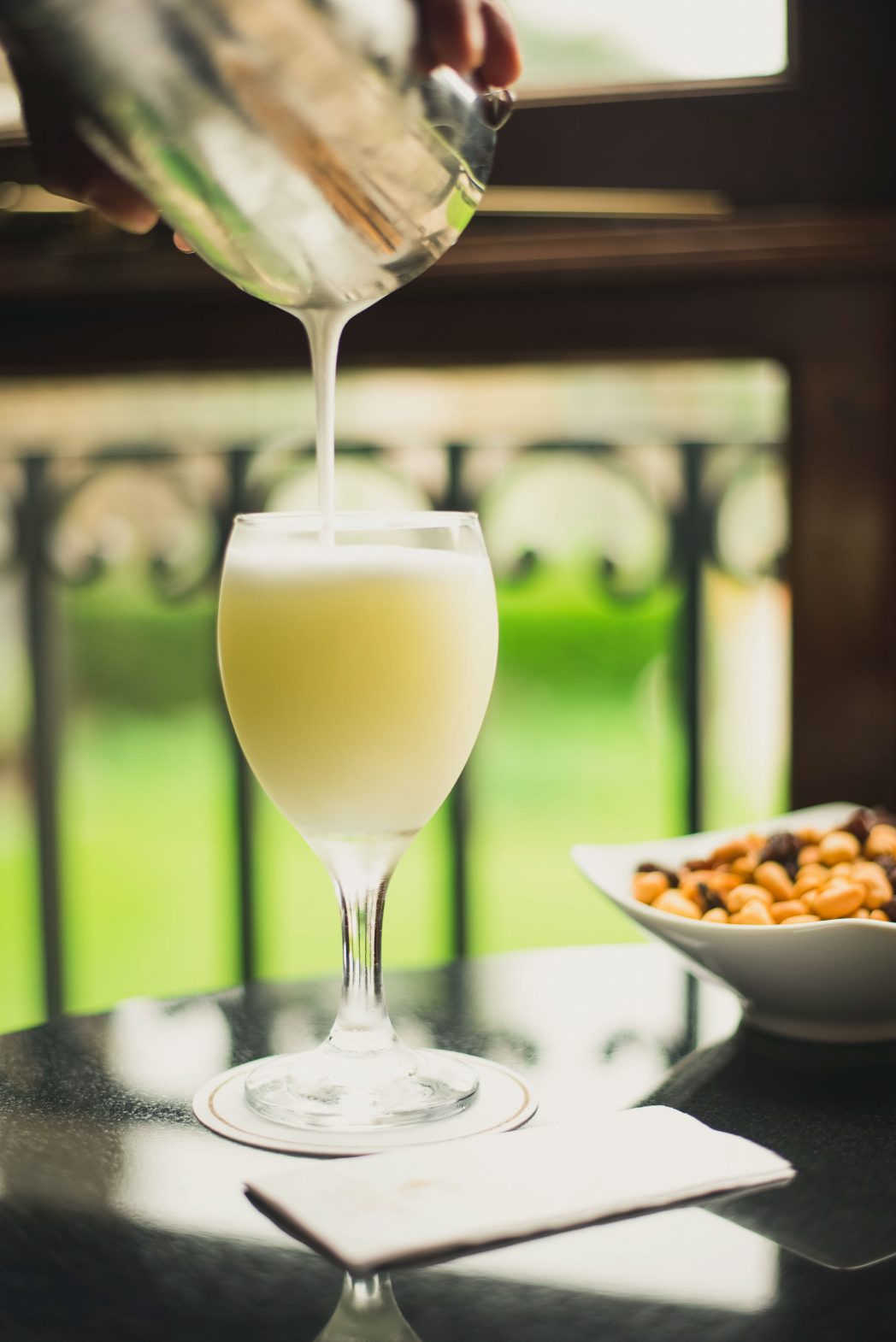A pisco sour is poured.