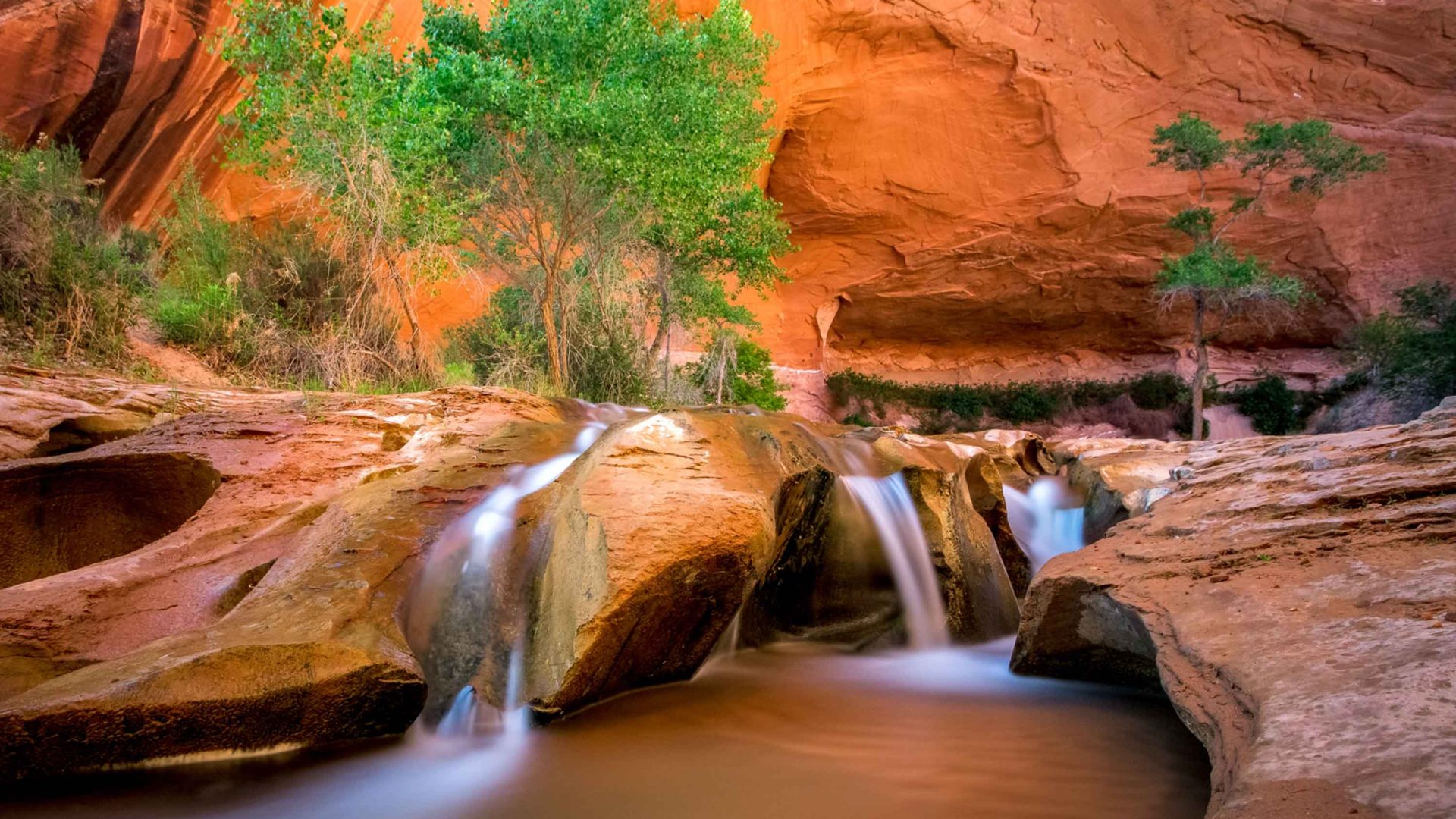 Water cascades through some red rocks.