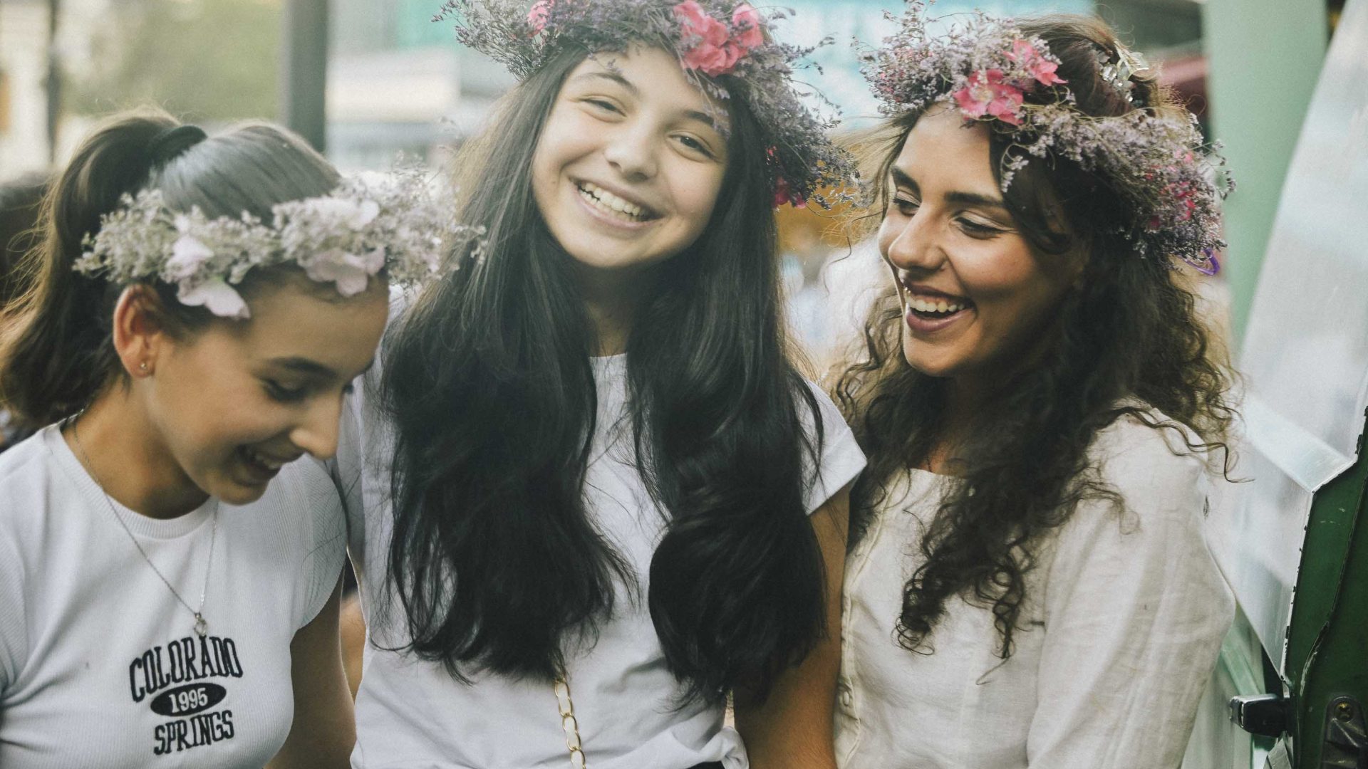 Three young women with floral arrangements in their hair.