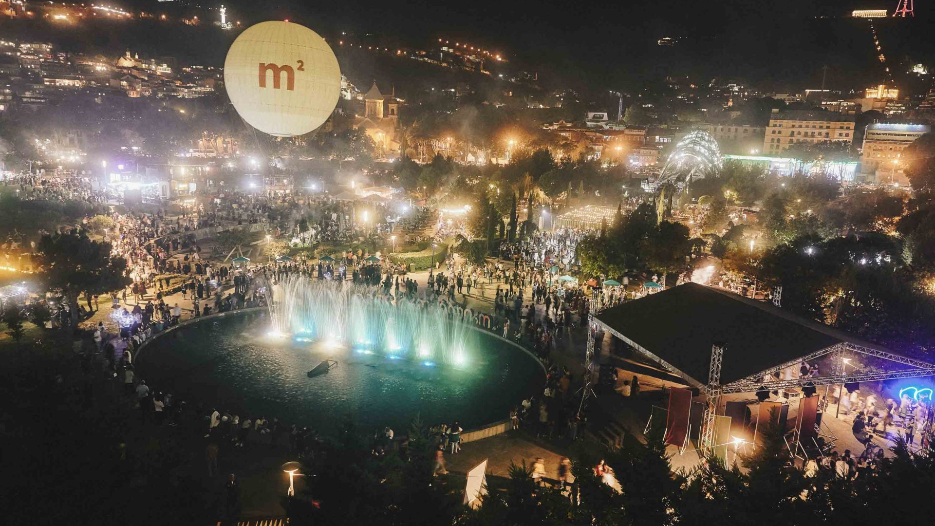Looking down at a brighly lit up festival at night.