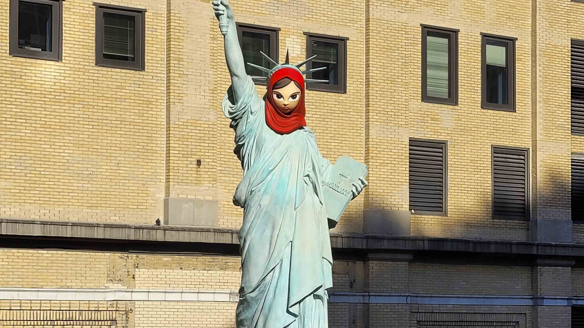 A piece of art that looks like Lady Liberty wearing a red hijab.