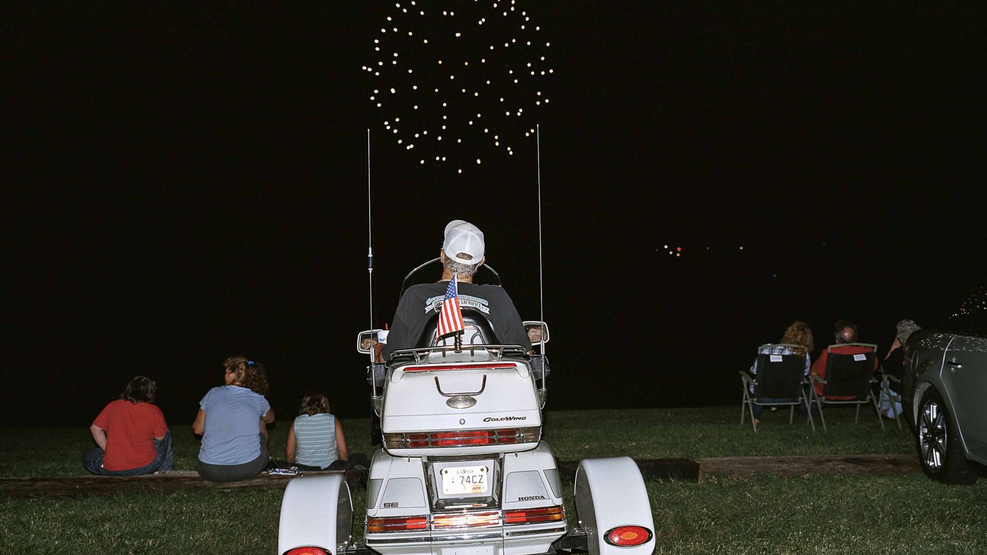 A man watches fireworks from a buggy.
