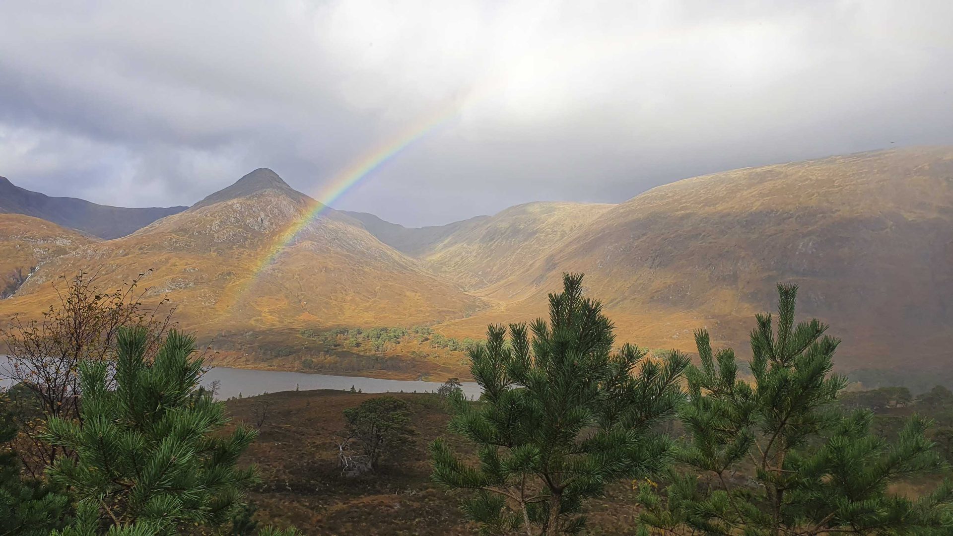 A rainbow over mountains and water.
