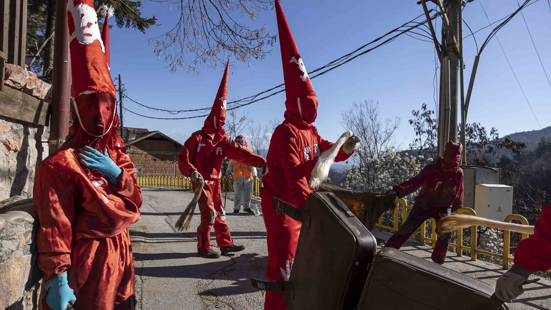 People in red costumes walk through the streets.
