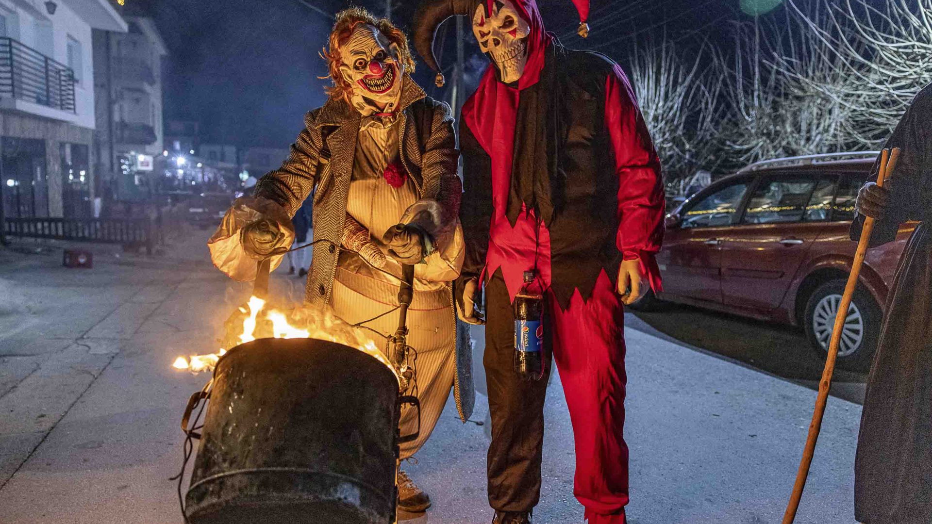 Two people in costume push a burning stroller.