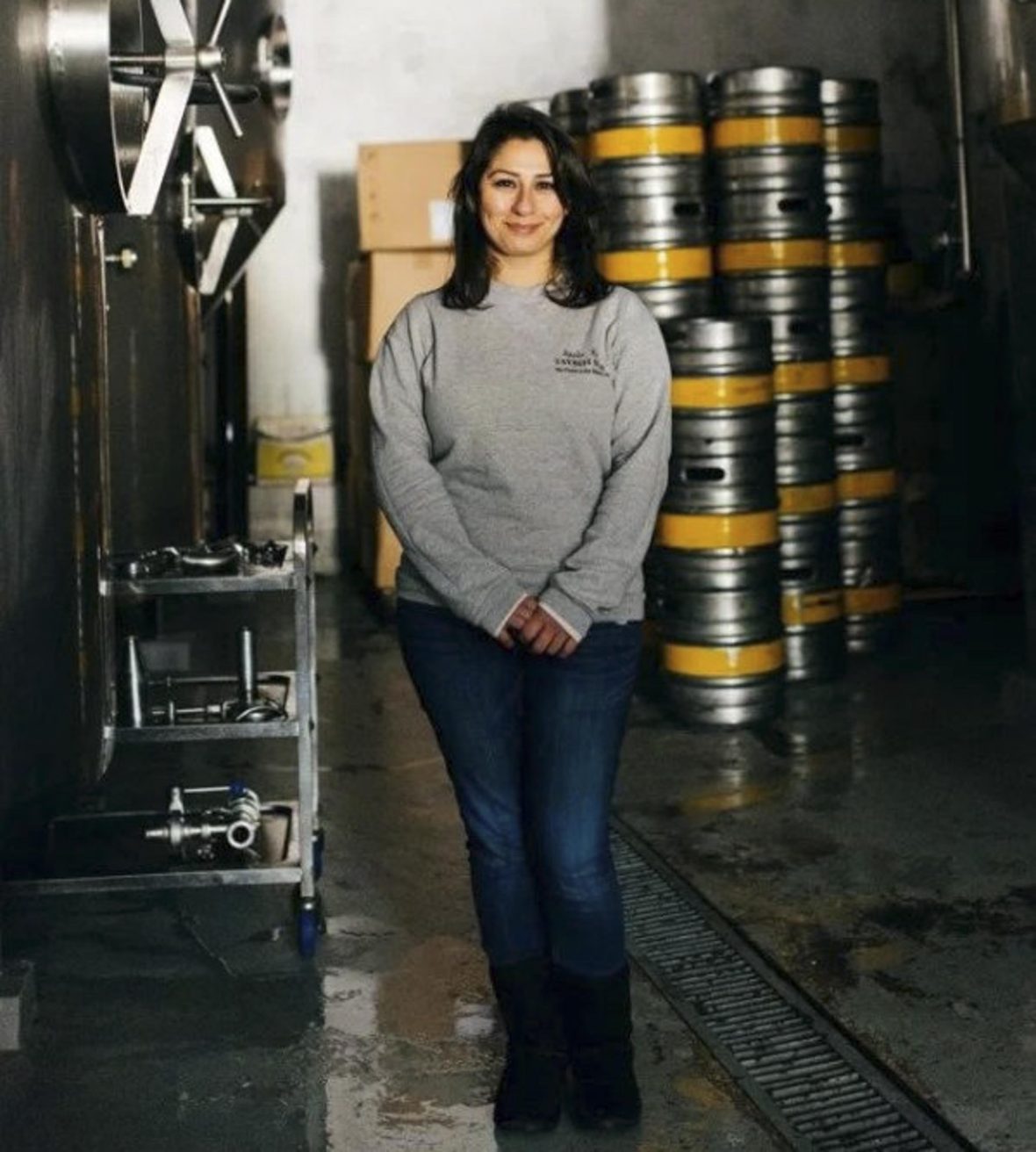 A portrait of Madees Khoury with beer barrels in the background.