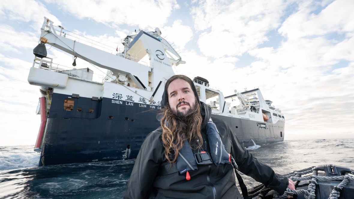 A man, Alistair Allan, pictured on board the Tempest giving an interview to Sea Shepherd Crew with a super trawler ship in the background.