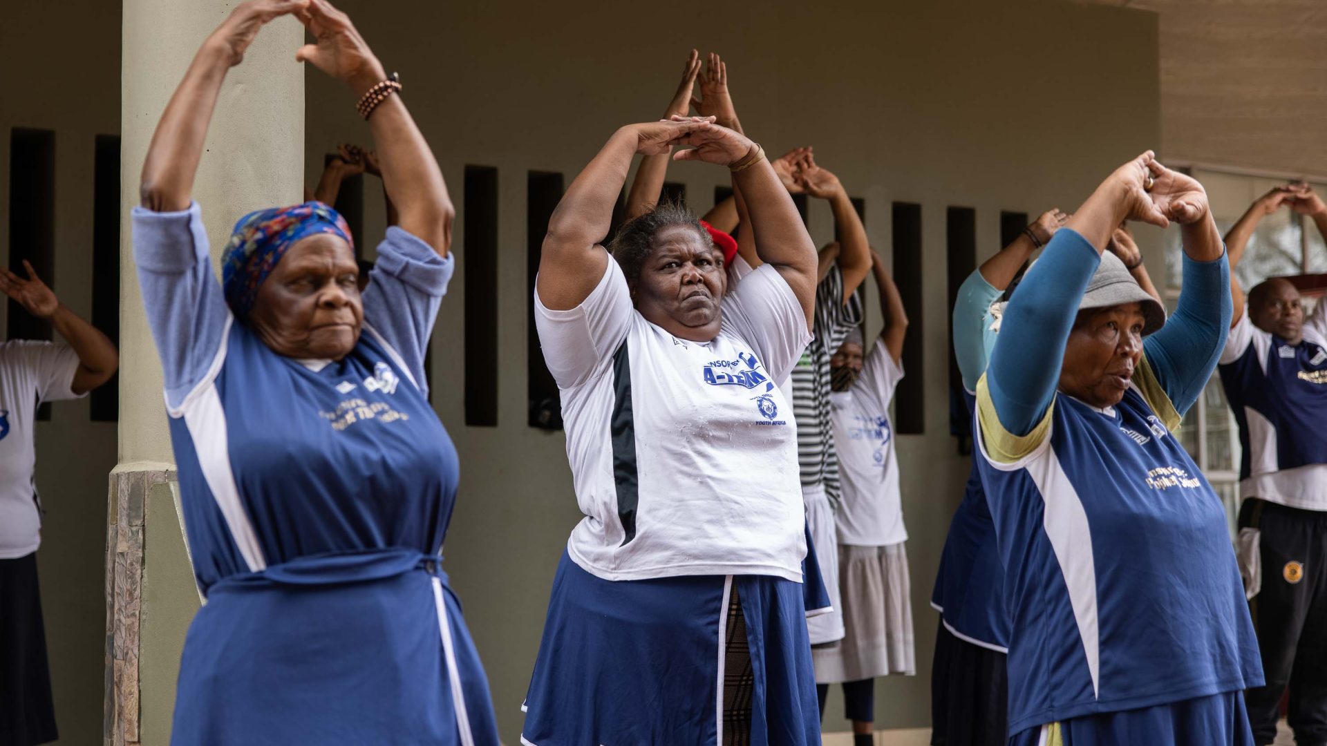 Boxing grannies workout with their arms in the air.