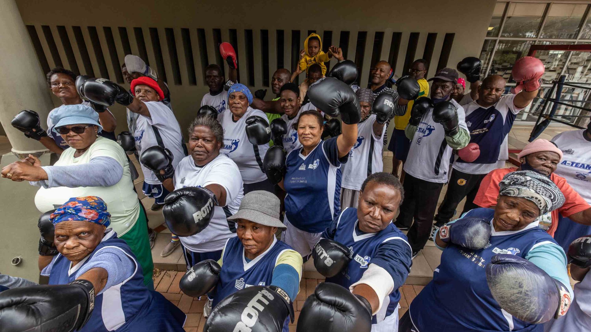 Members of boxing grannies raise their boxing gloves.