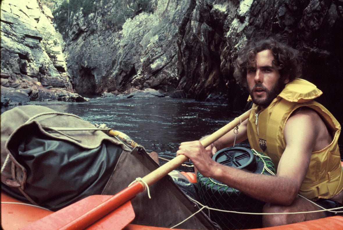 A man in a yellow life jacket rafting down the Franklin River in Tasmania, Australia in 1976.