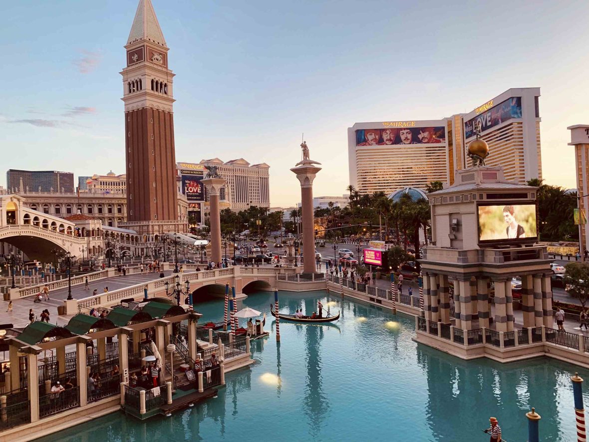 The elaborate recreated canals and bell tower of Venice, with the hotel building in the background, that makes up The Bellagio hotel Las Vegas.