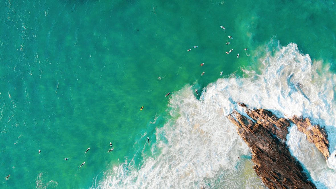 An aerial view of surfers in the water awaiting bigger waves at Snapper Rocks Road in Coolangatta, Australia.