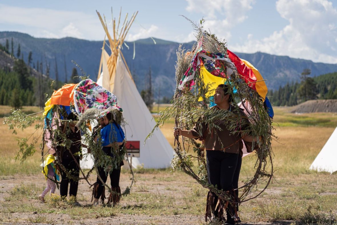 Dancers and their buffalo sculptures. The buffalo sculptures were built using willow branches, red willow (water birch) branches, sage, twine, and silk handkerchiefs.
