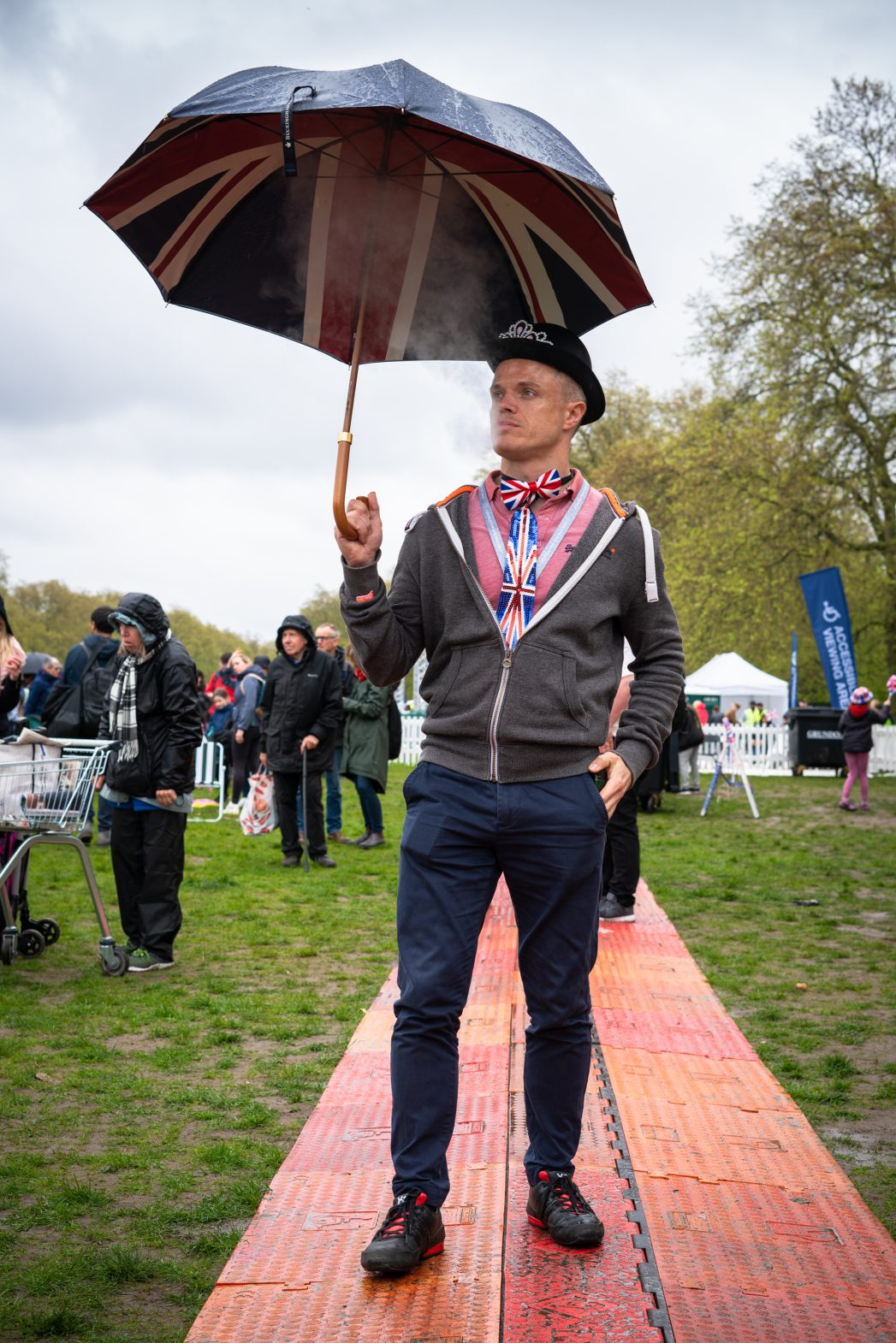 A smartly dressed man photographed wearing a Union Jack tie and umbrella.