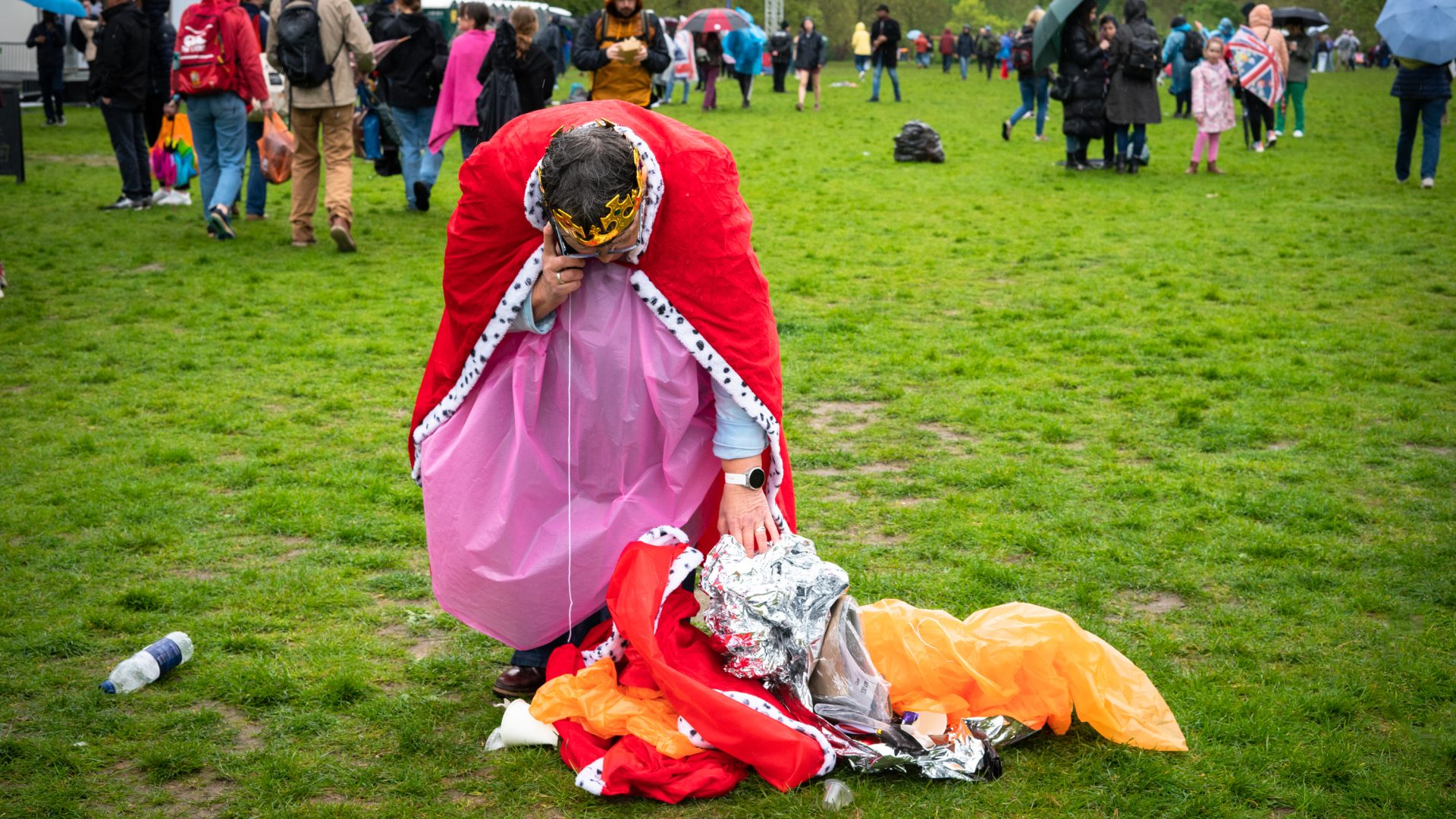 A man dressed in a royal gown and cape pictured in the park.