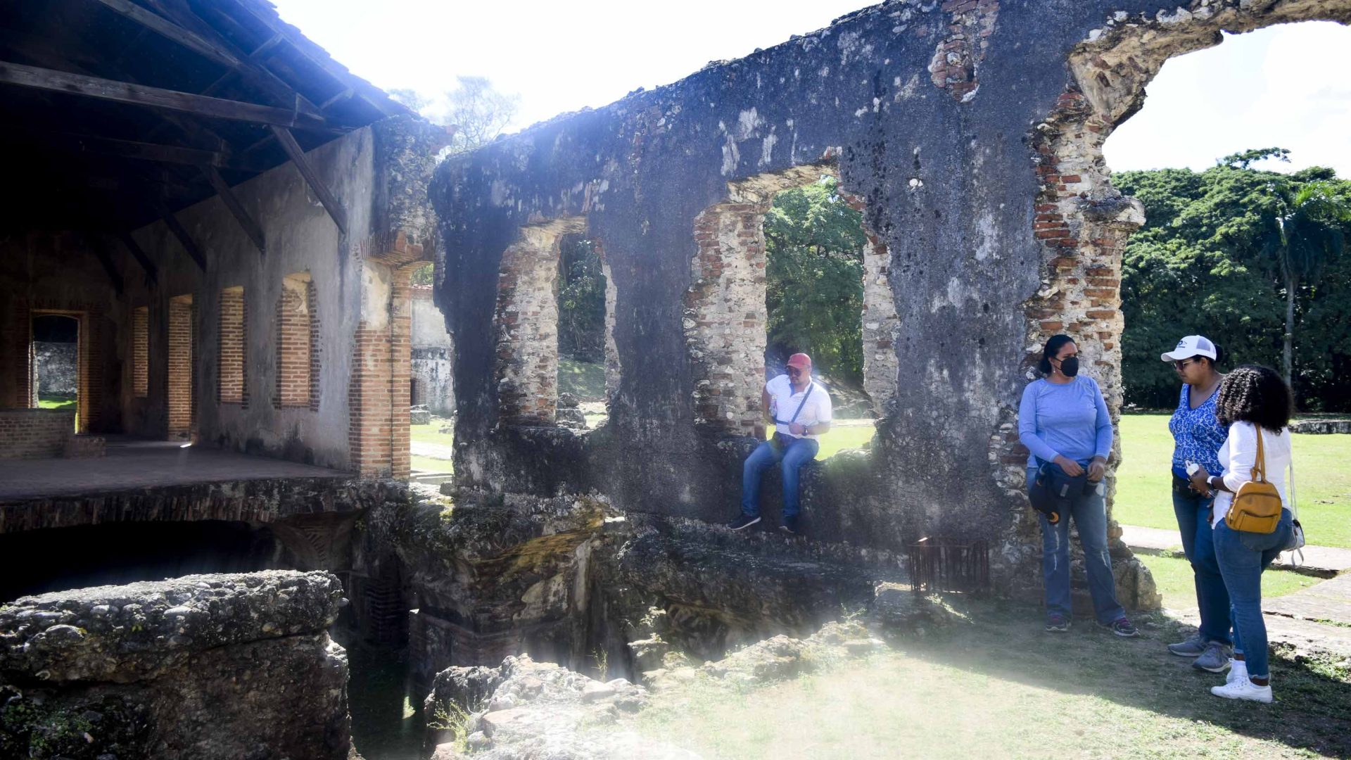 People sit around the ruins of a building