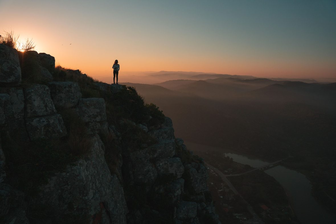 A person looks out over South Africa's Wild Coast at dusk.
