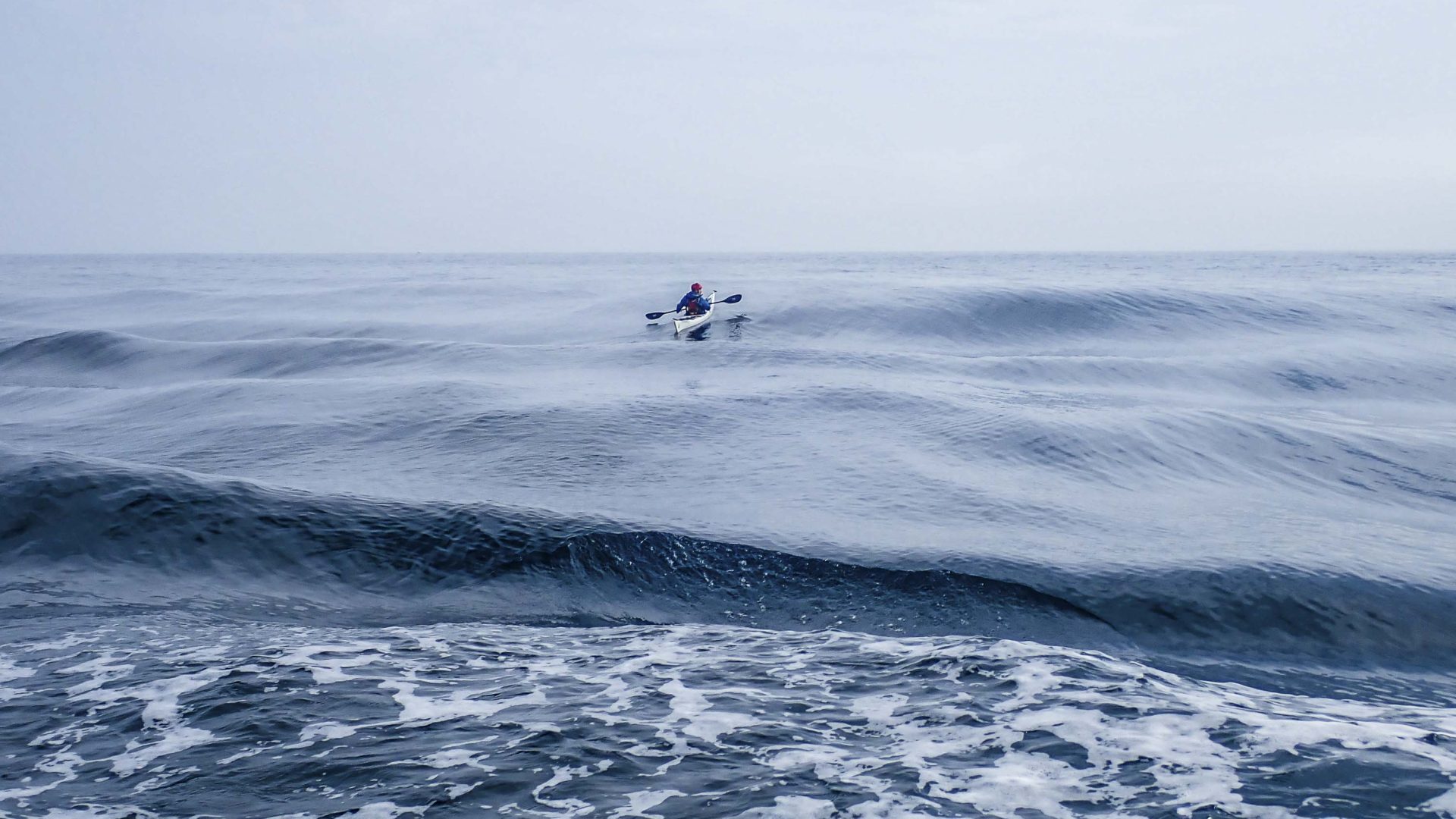 A lone kayaker in still water.