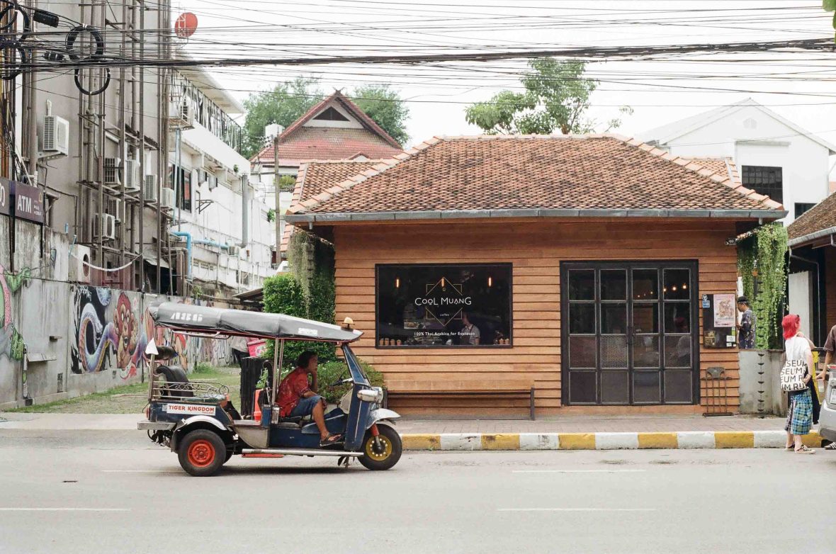 A tuk tuk drives past a cafe in Chiang Mai.