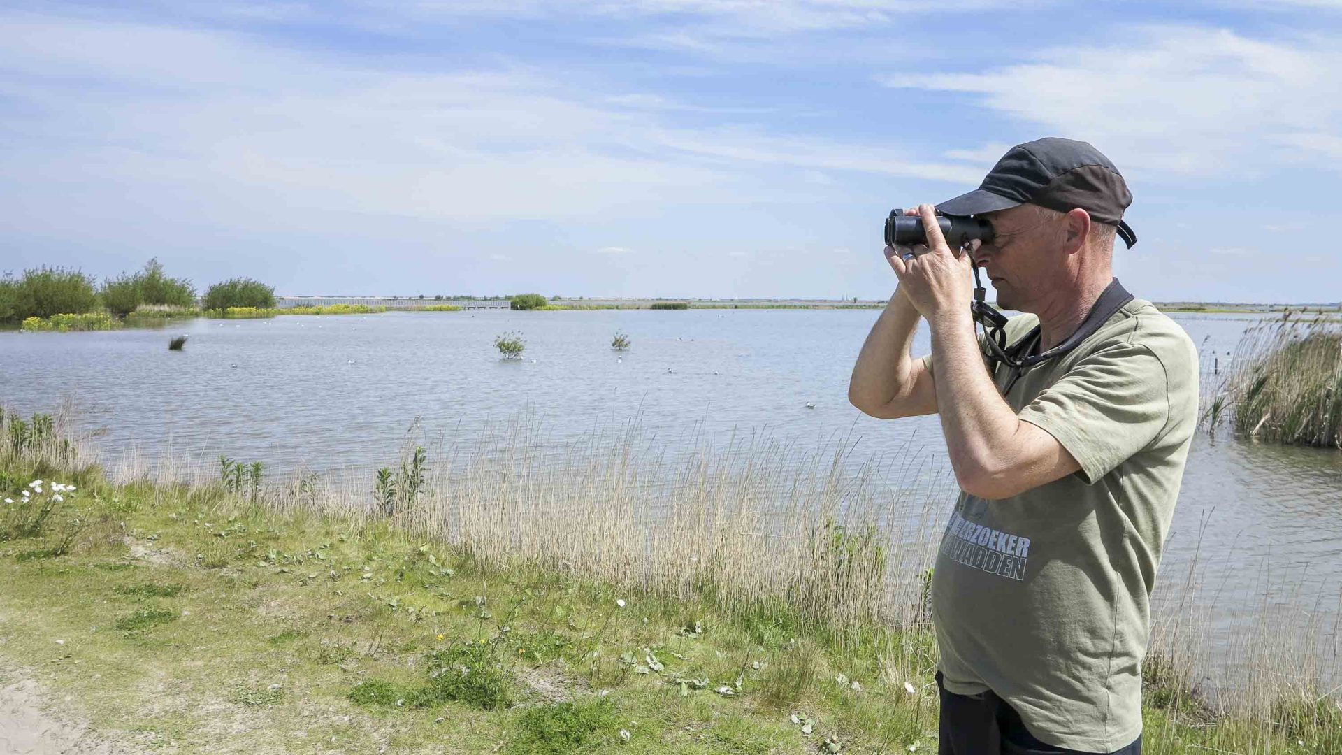 A man uses binoculars to look out for birds.