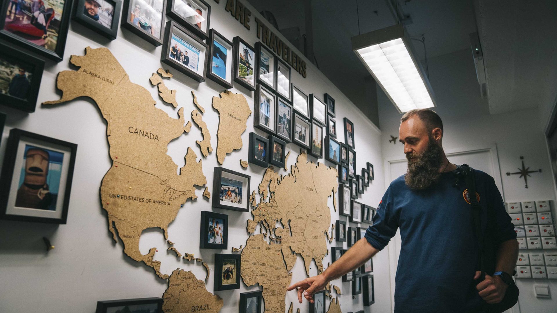 Thor points to a map of the world which is on the wall, indicating a country he has been to.