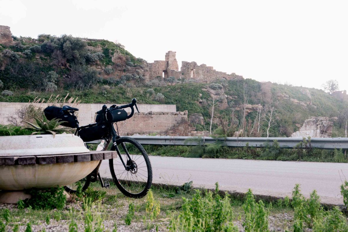 A bike leans while in the background are old buildings.