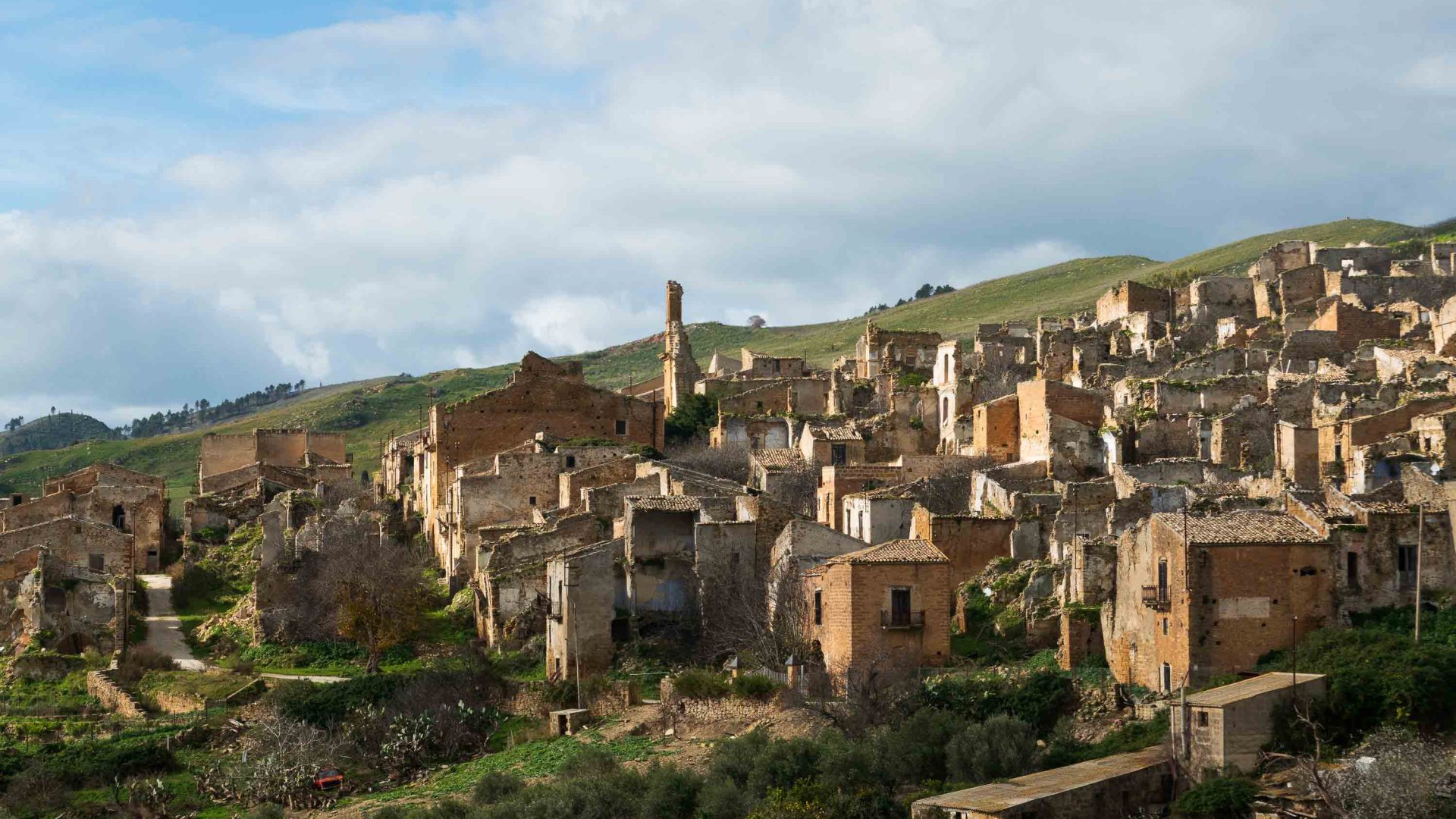 The ghost town of Poggioreale with old stone houses in a valley.