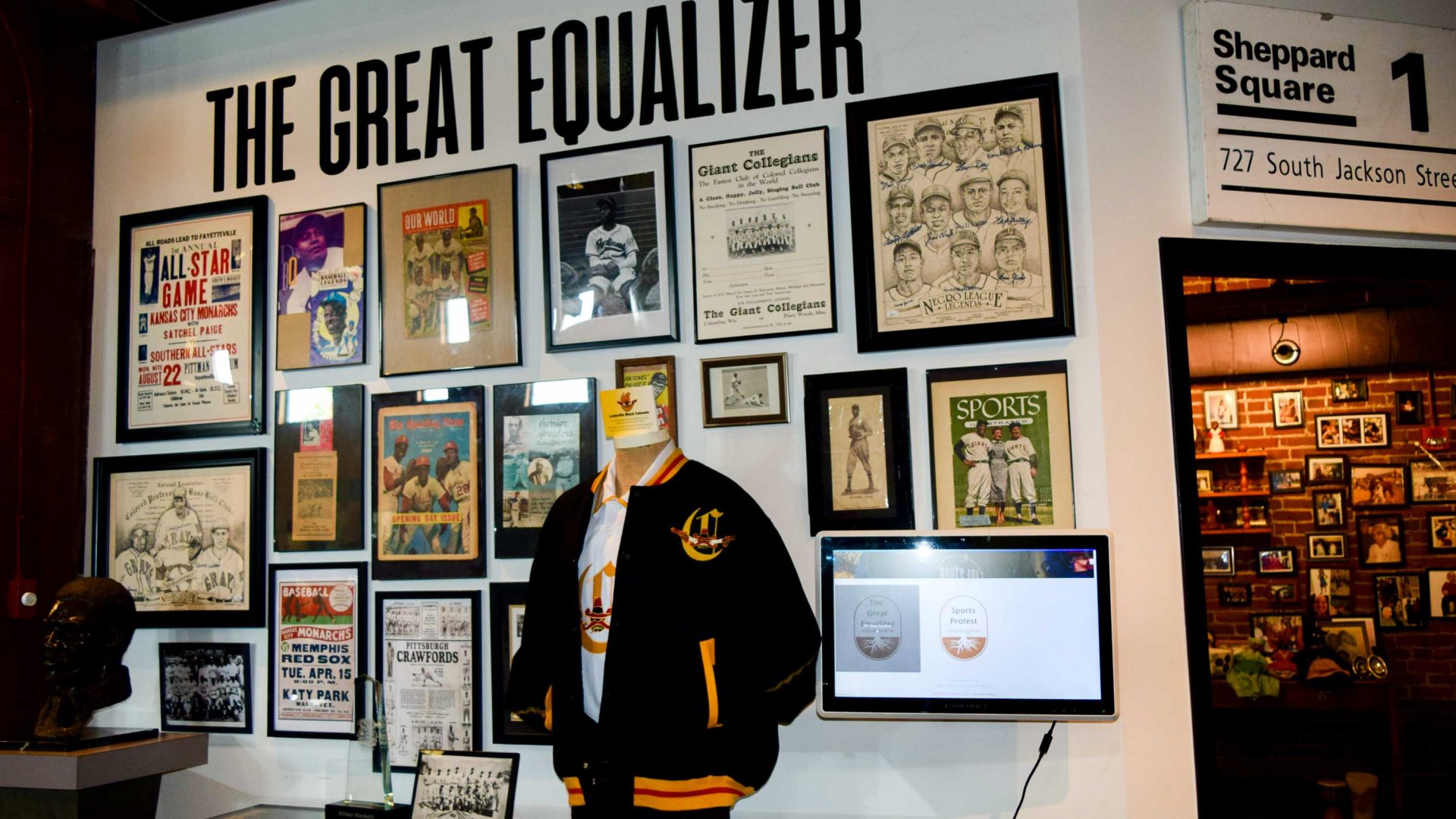 A wall says the Great Equalizer and has framed prints on it.