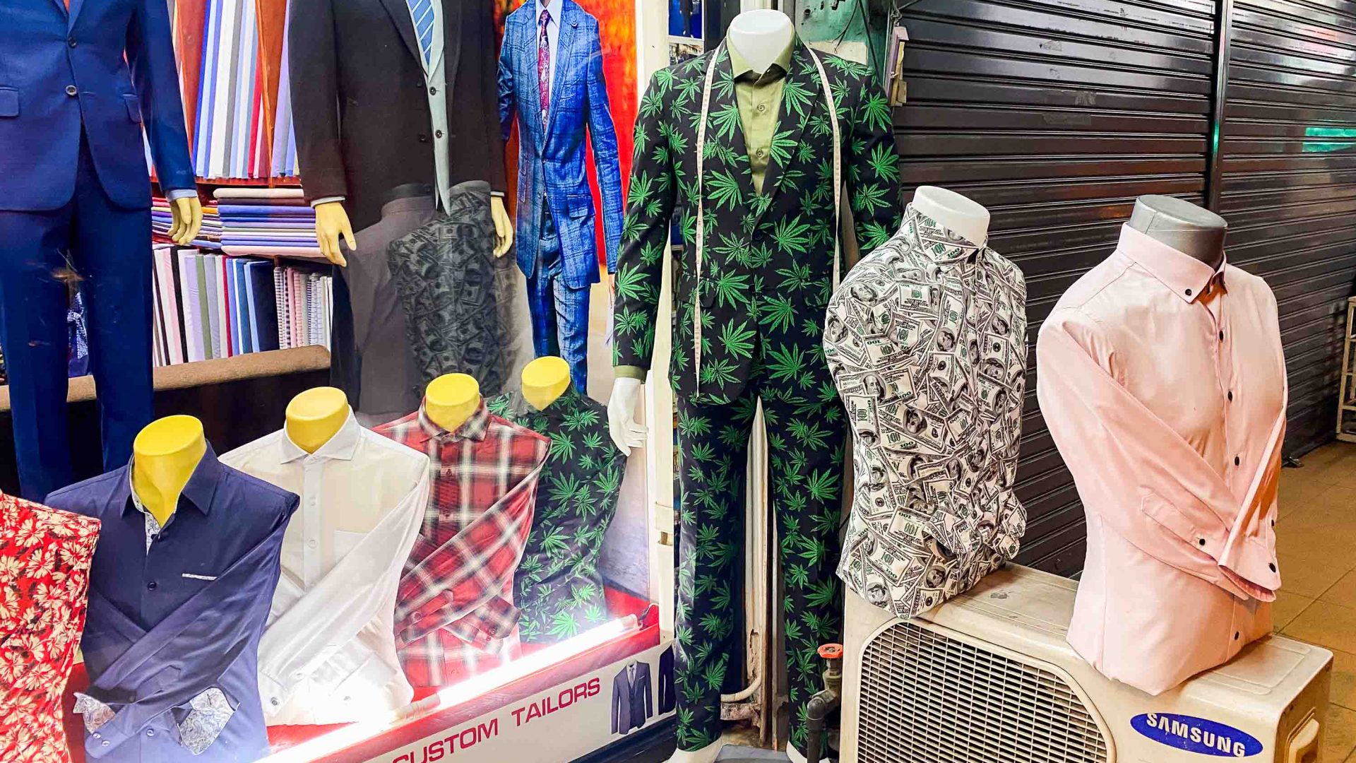 A suit with cannabis leaves printed on it os for sale amongst other clothes outside of a shop in Thailand.