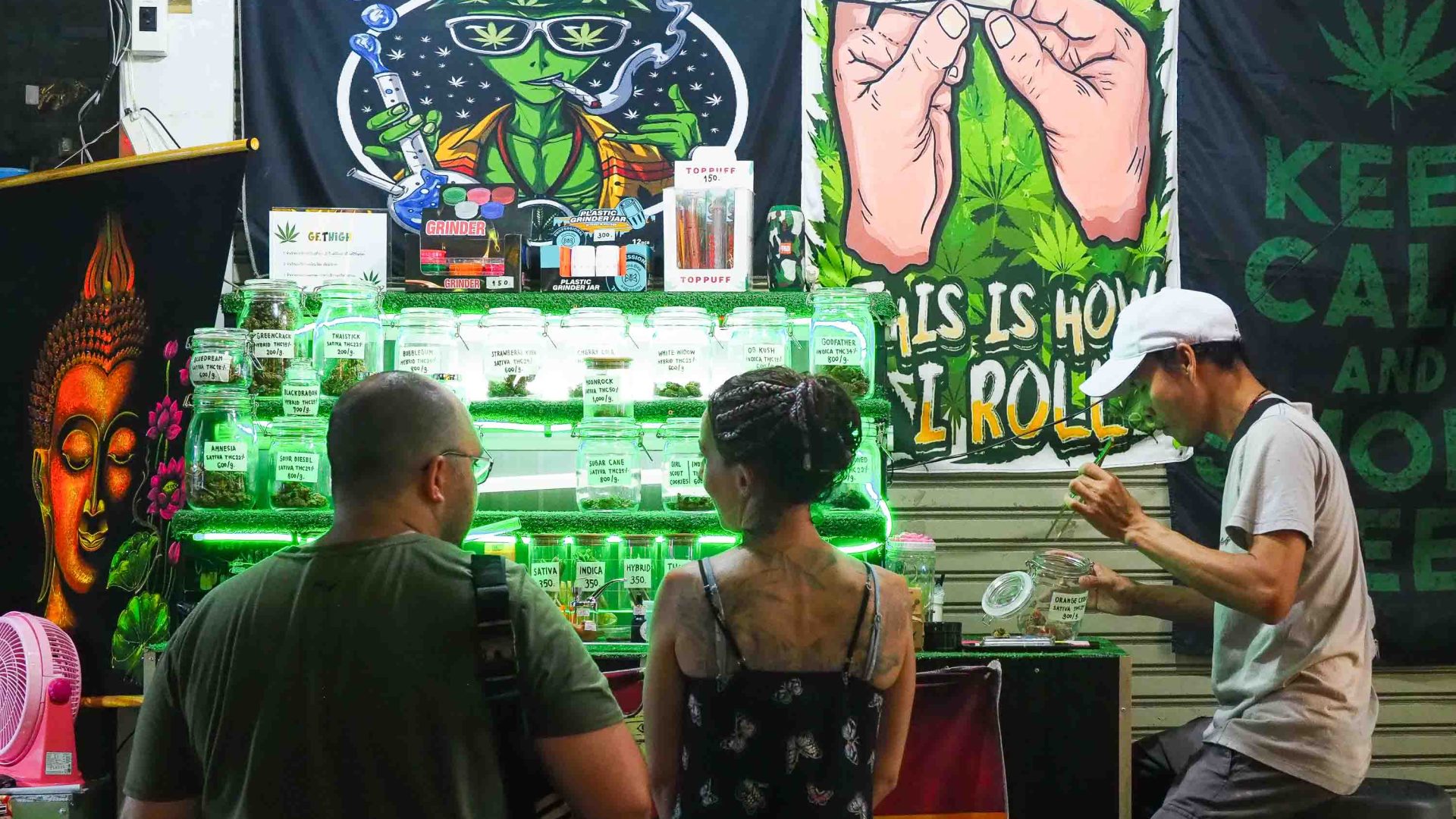 Tourists stand at a bar selling cannabis products.