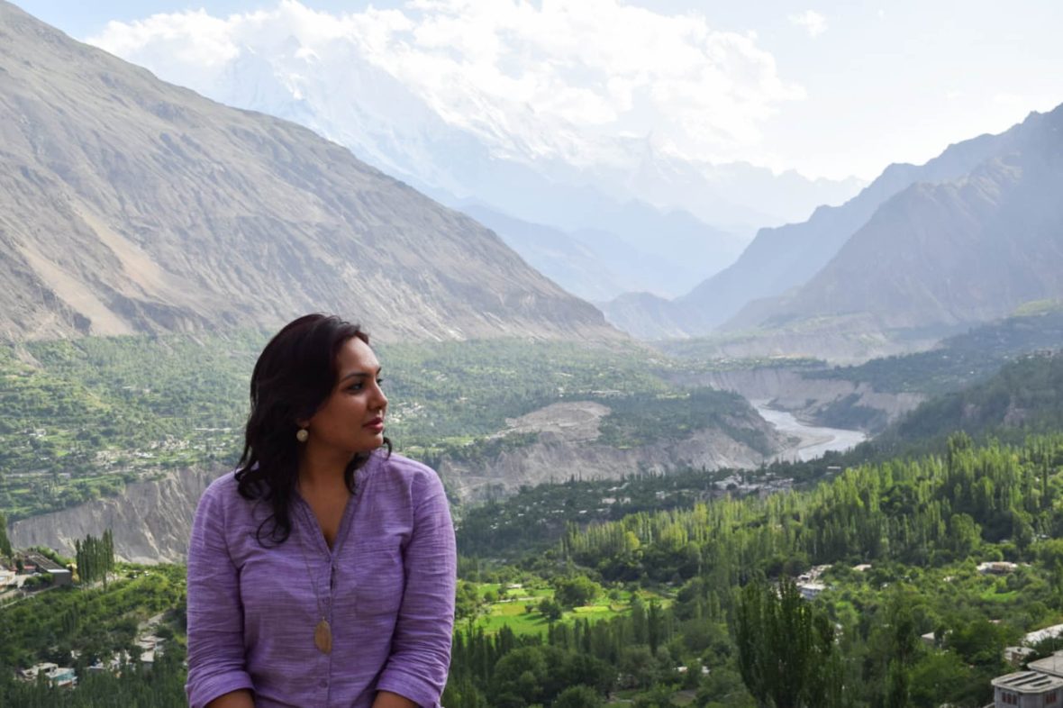 Intrepid Tour guide Aneeqa Ali sits in front of some of the mountains in Pakistan.