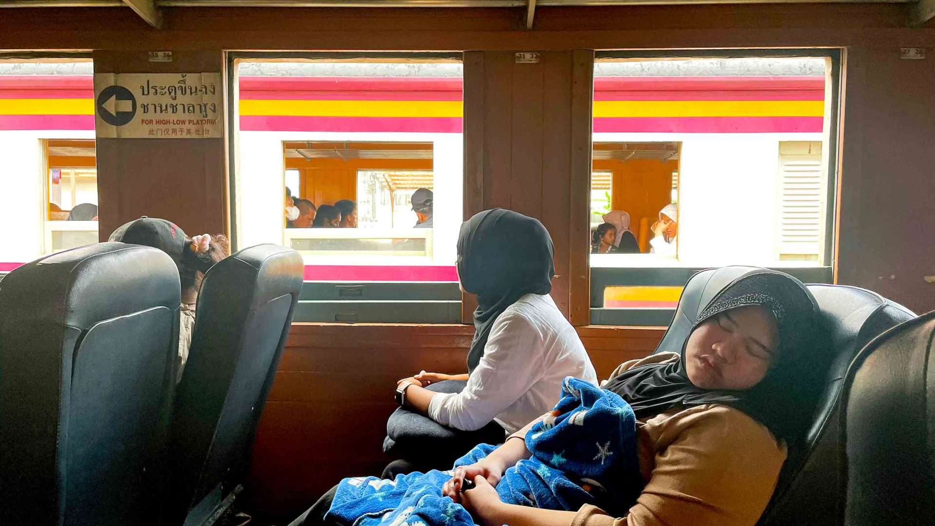 A person sleeps in one of the train carriages.