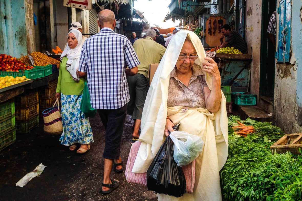 People walk through a local food market in Tunisia.
