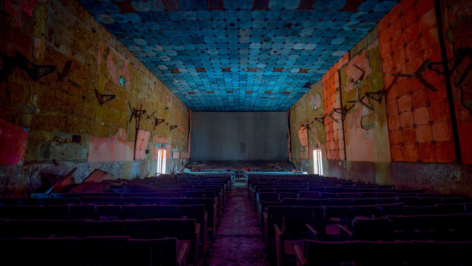 An old cinema with a blue ceiling and orange walls.