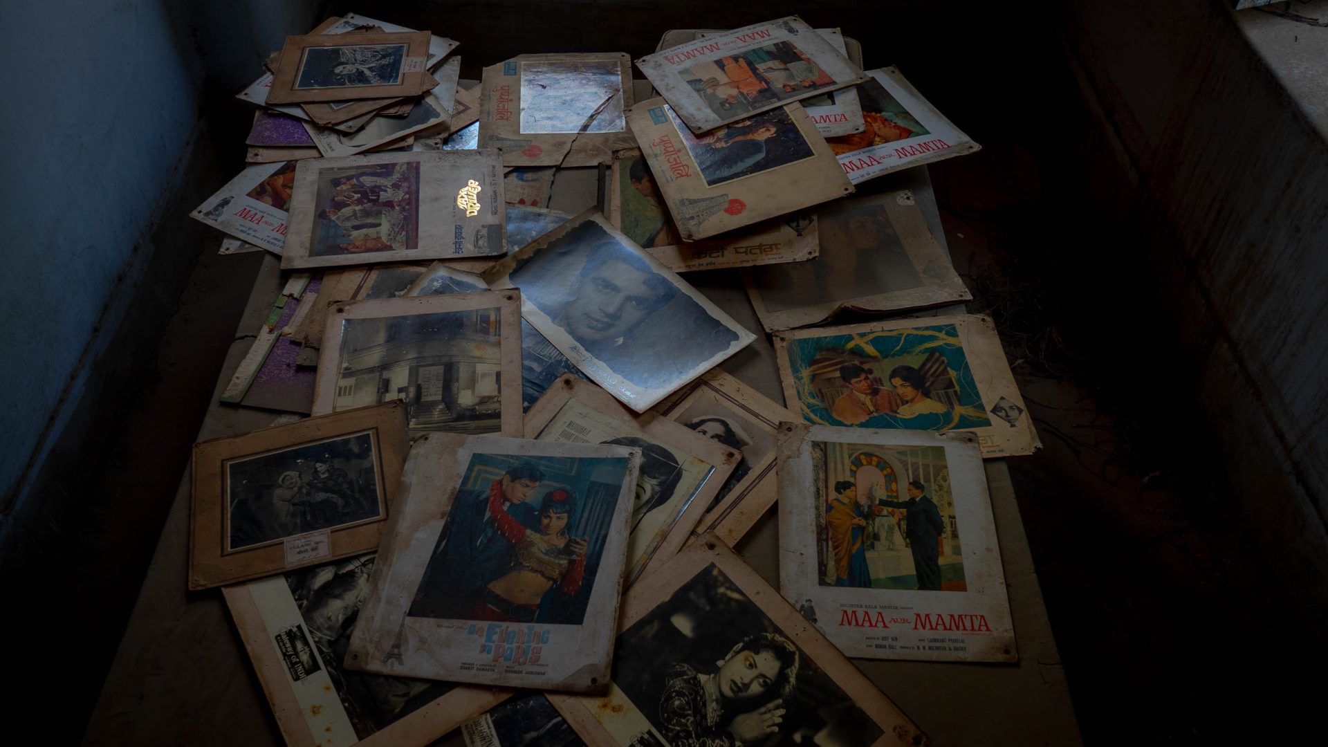 A collection of old cinema posters lies on a table.