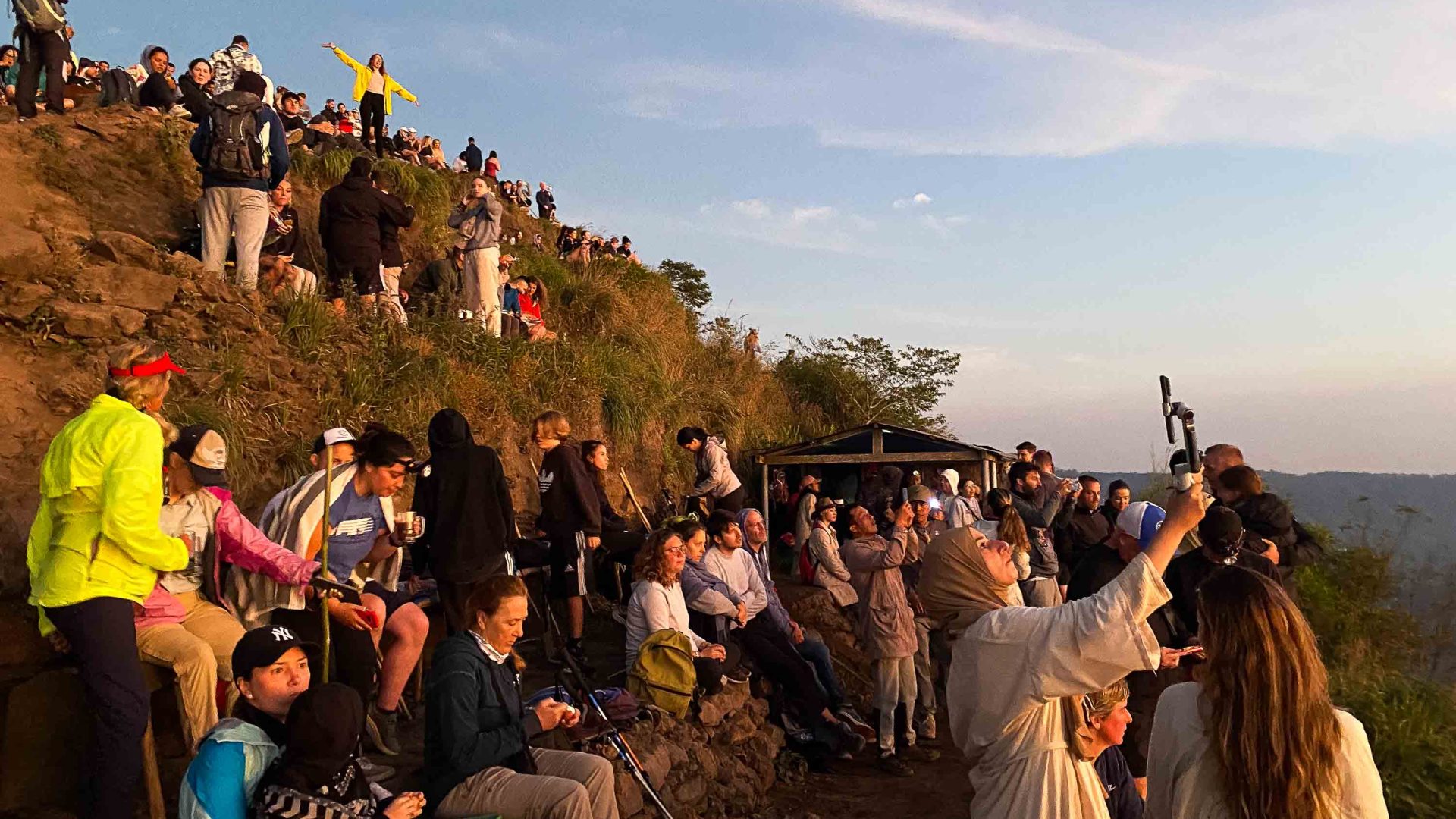 Hoards of tourists take photos of the sunrise over Mt Batur.