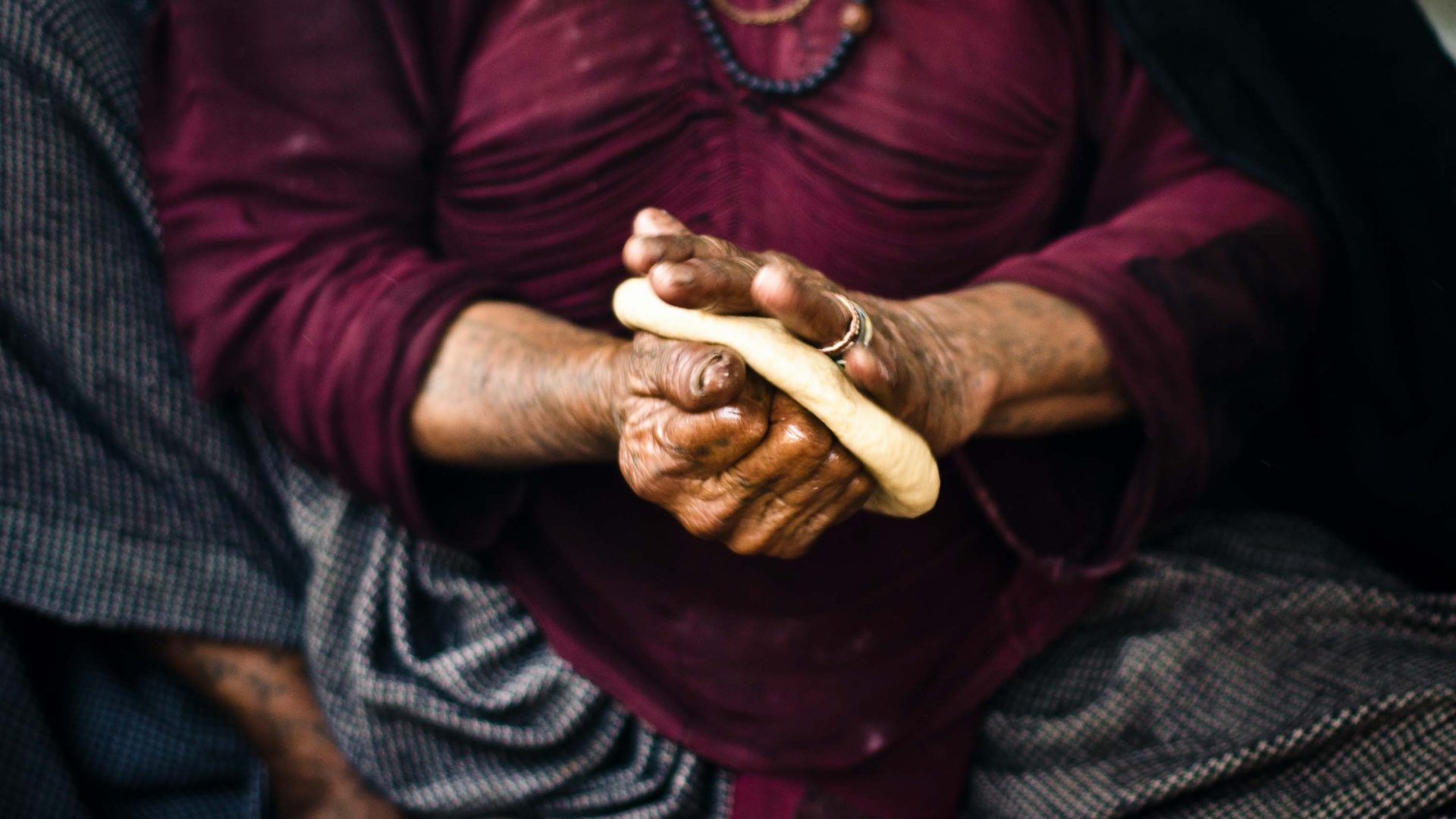 A woman kneads dough to make bread.