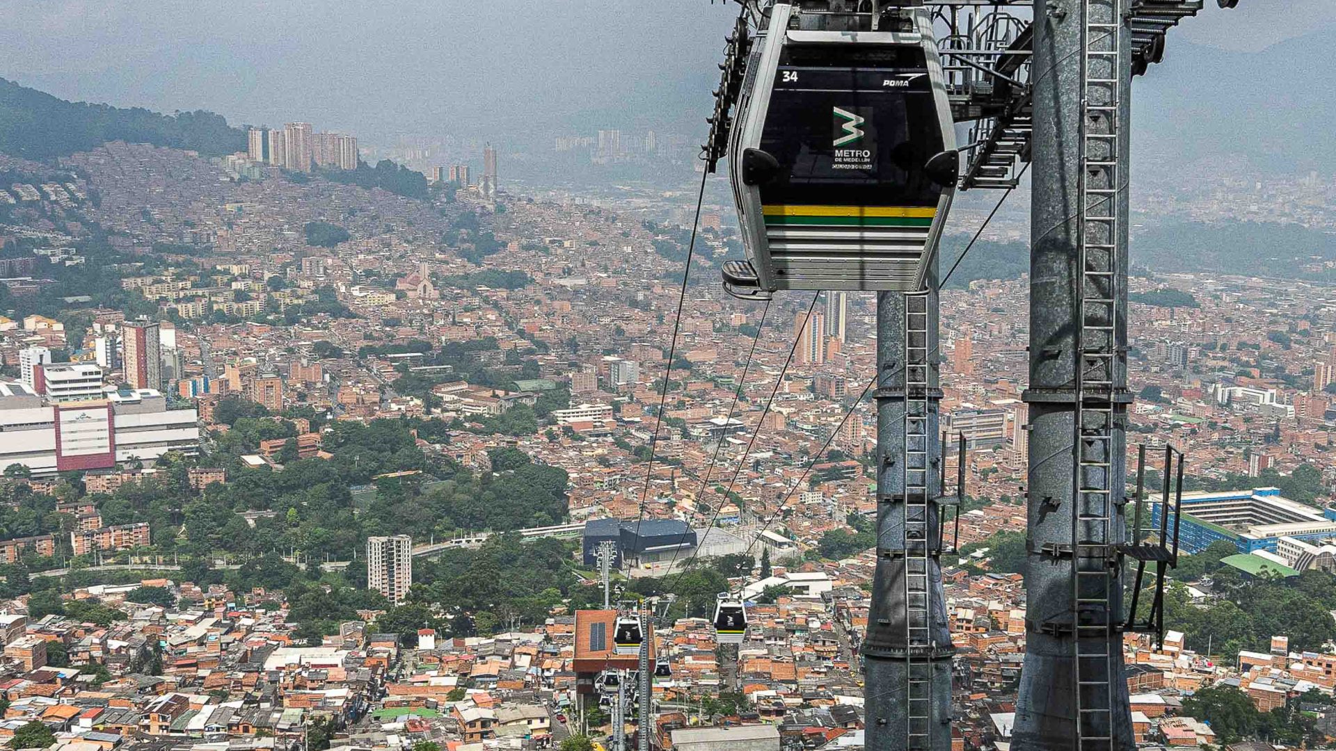 The Metrocable travels up the hill, with views of the city behind it.