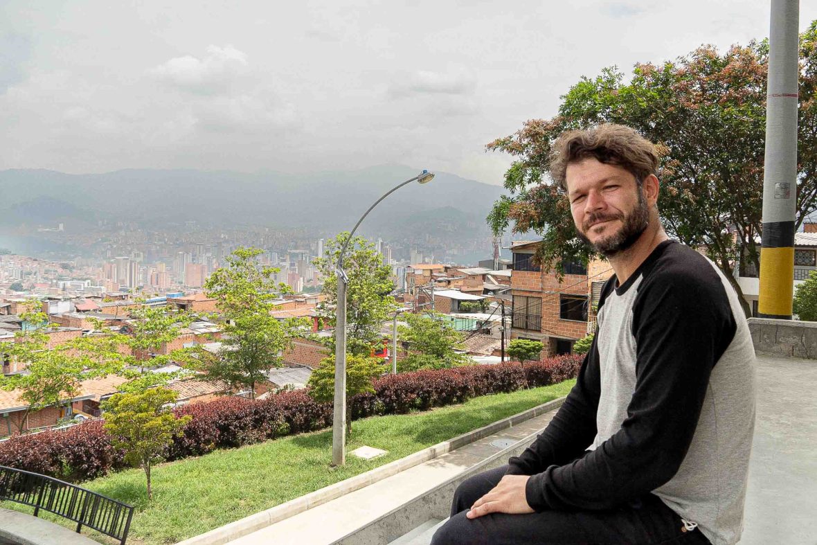 Ruben, an Impulse Travel tour guide sits down with the city of Medellin in the background.