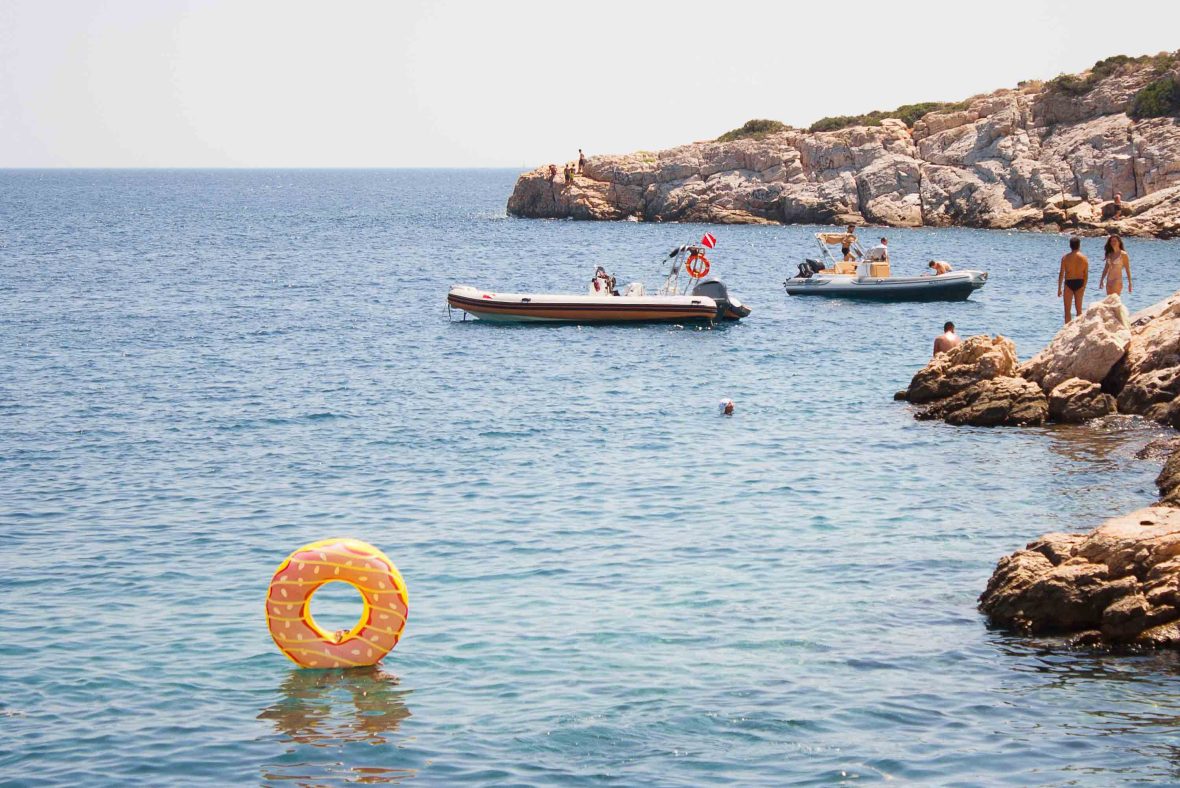 People on boats in the background and a donut flotation ring in the foreground.