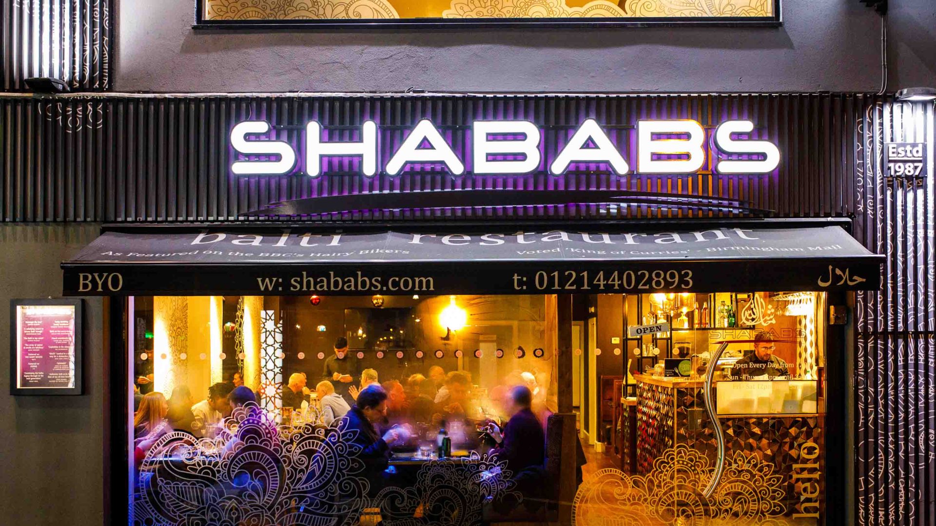 The exterior of Shababs. People sit outside, dining.