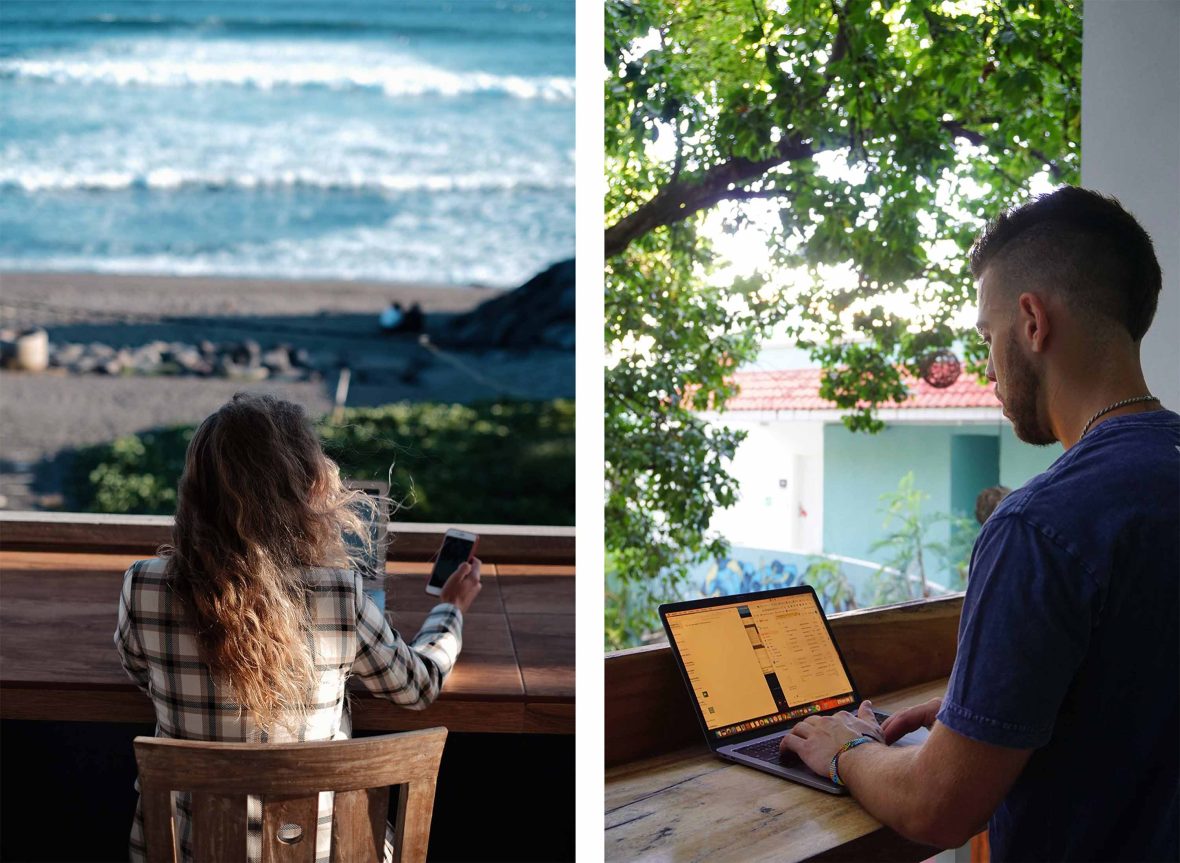 Two digital nomads work at their laptops.