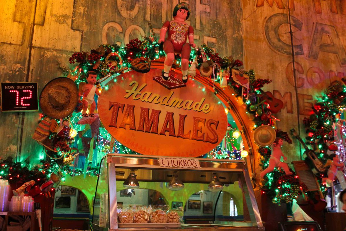 A sign for Tamales is fringed with colourful lights.
